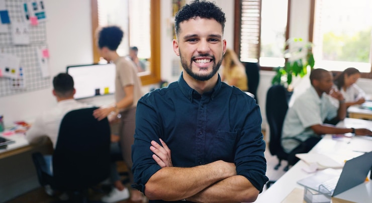Foto homem feliz e retrato de designer com os braços cruzados no local de trabalho do escritório para negócios confiança facial e design gráfico pessoa do sexo masculino ou empresário criativo profissional e mentalidade de liderança