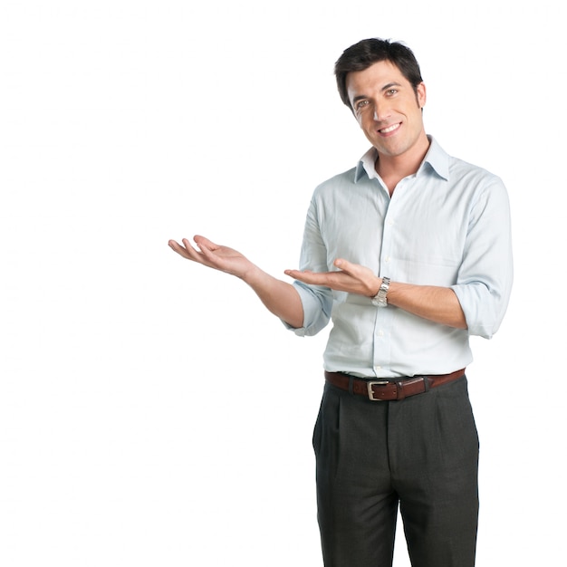 Homem feliz e sorridente na camisa, apresentando e mostrando algo no fundo branco