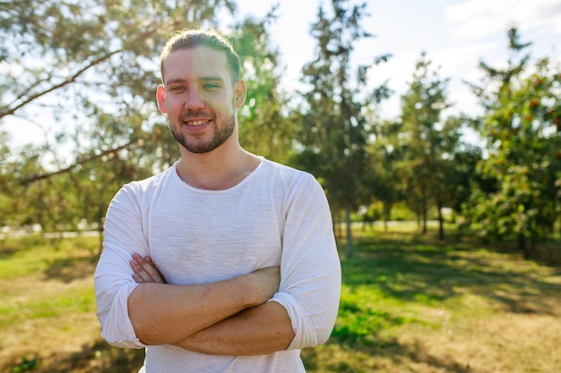 Homem feliz em blazer branco contando uma história interessante para um amigo ao ar livre no parque de verão