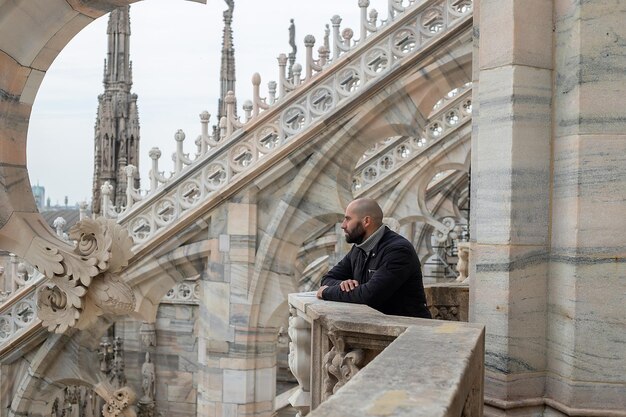 Foto homem feliz em frente à catedral do duomo de milão