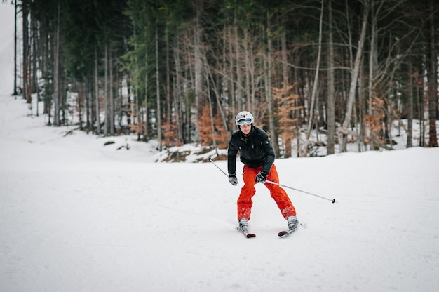 Homem feliz esquiando nas montanhas nevadas