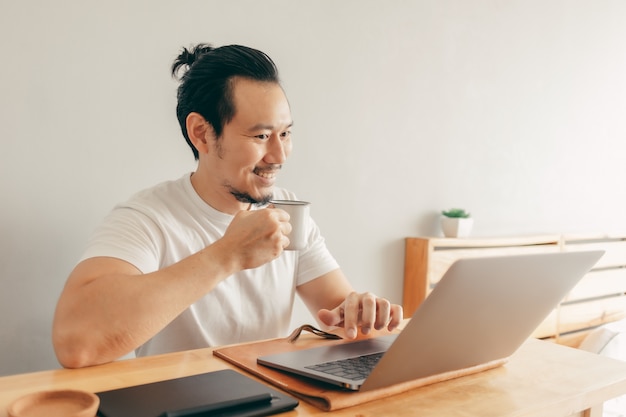 Homem feliz está trabalhando em seu apartamento no conceito de trabalho em casa.