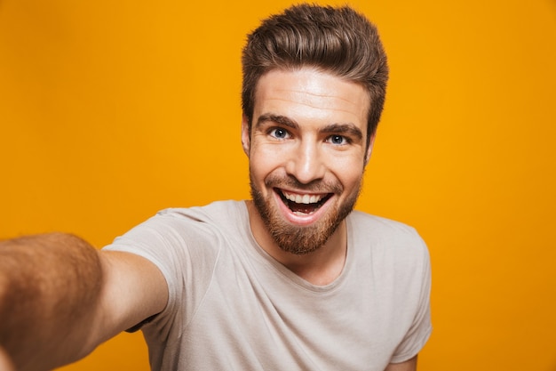 Homem feliz faz uma selfie pela câmera.