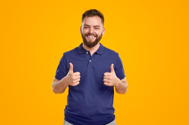 Homem feliz, mostrando os polegares no estúdio