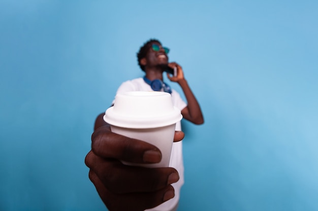 Homem feliz mostrando uma xícara de café para a câmera