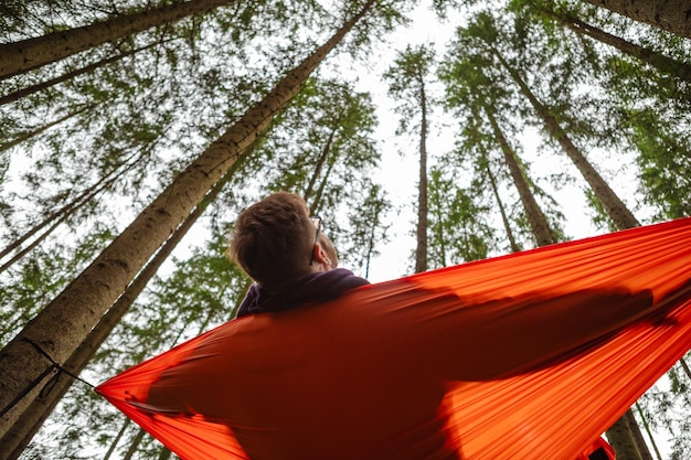 homem feliz na rede no meio do espaço da cópia da floresta