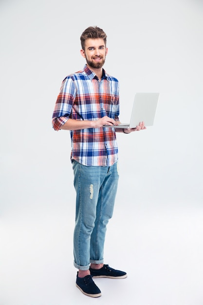 Homem feliz parado com um laptop