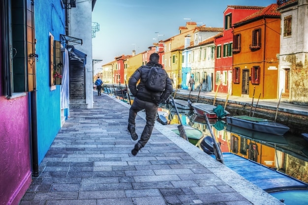 Homem feliz pulando em burano itália