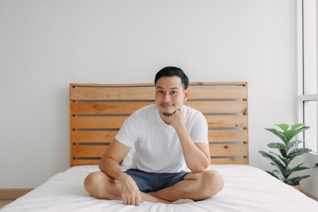 Homem feliz relaxando e relaxando na cama, o conceito de mente saudável