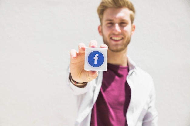 Homem feliz, segurando, facebook, ícone, cubo