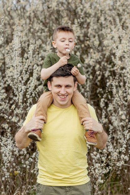 Homem feliz segurando o filho nos ombros