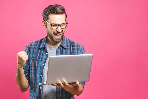 Foto homem feliz, segurando o laptop e comemorando seu sucesso