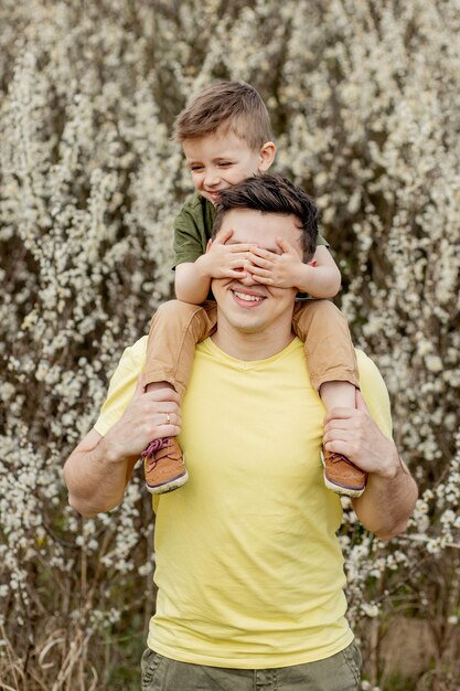 Homem feliz segurando seu filho enquanto se diverte.