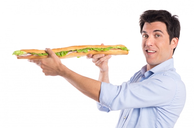 Homem feliz segurando um sanduíche de baguete longa