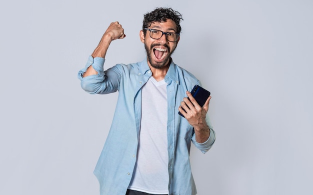 Homem feliz segurando um smartphone e comemorando um cara animado olhando para seu smartphone