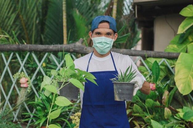 Homem feliz segurando um vaso de flores em uma loja de enfeites de jardim