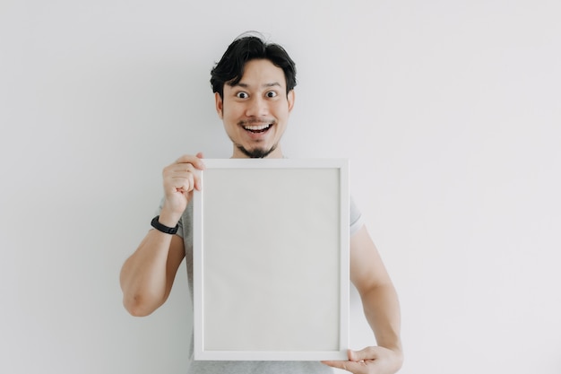 Foto homem feliz segurando uma moldura vazia isolada no fundo branco