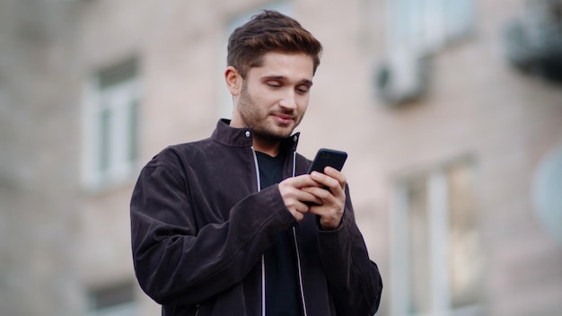 Homem feliz usando telefone do lado de fora Cara sorridente conversando por telefone ao ar livre