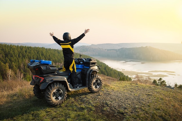 Homem feliz viaja de carro ATV nas montanhas Conceito de viagem e aventura