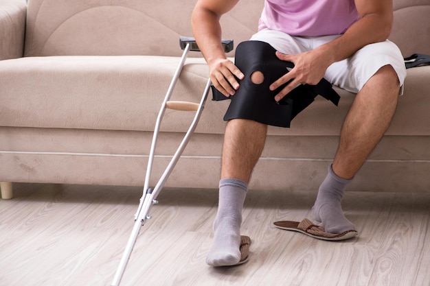 Foto homem ferido se recuperando em casa de lesão esportiva