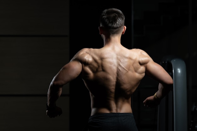 Homem fisicamente mostrando suas costas bem treinadas