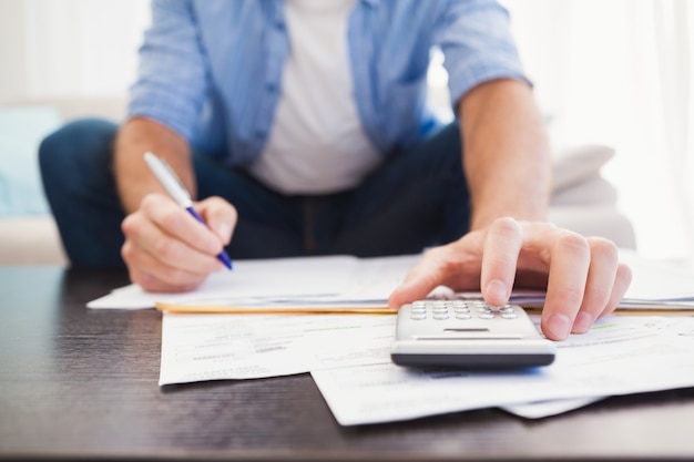 Homem focado calculando suas finanças