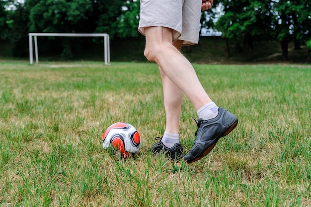 homem fora de um balanço bate uma bola.