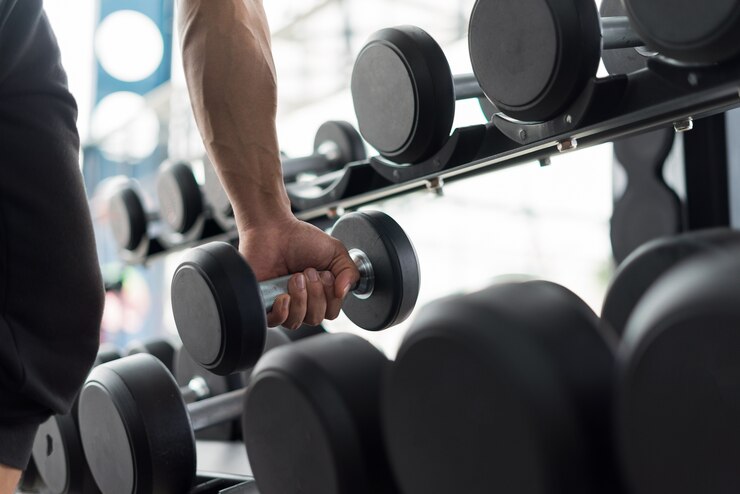 homem forte aptidão posando de corpo musculoso e fazendo exercícios para fisiculturista no ginásio