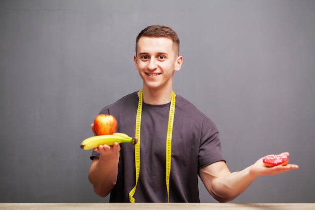 Homem forte consome uma refeição rica em proteínas e frutas