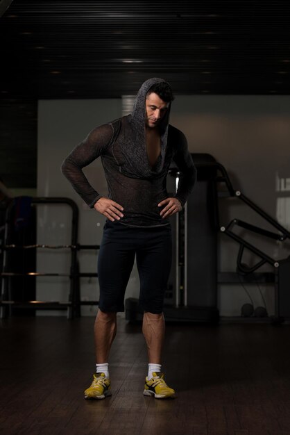 Homem forte em camiseta preta fundo ginásio