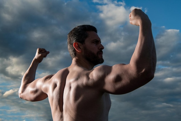 Homem forte fisiculturista homem sem camisa com corpo fitness homem atlético com bíceps e tríceps