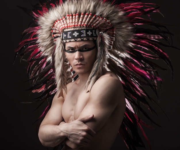 Homem forte indiano posando com maquiagem tradicional americana nativa