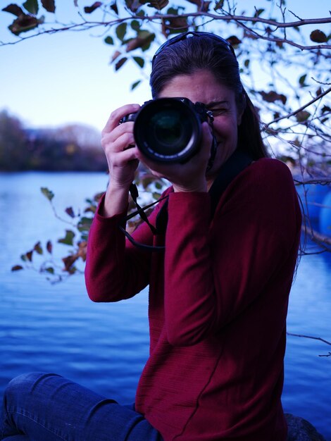 Foto homem fotografando com o reflexo no lago