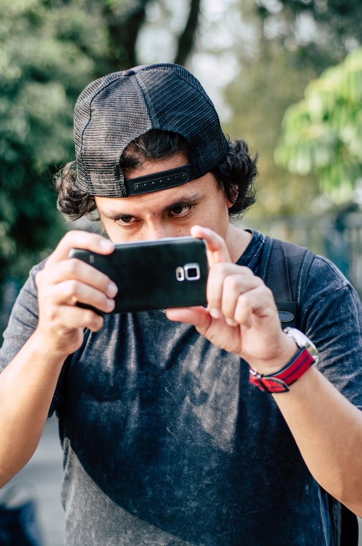 Foto homem fotografando com telefone celular no parque