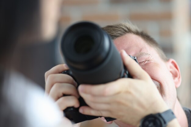 Homem fotografando mulher usando câmera profissional negra profissão do conceito de fotógrafo