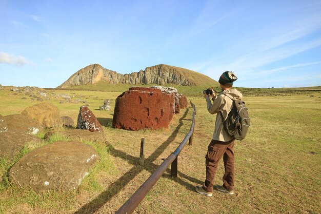 Homem fotografando os Top Knots ou da estátua Moai no local Ahu Tongariki na Ilha de Páscoa Chile