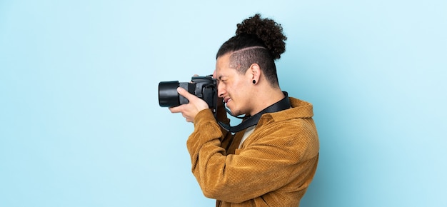 Homem fotógrafo sobre azul isolado