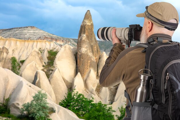 Homem fotógrafo turístico com uma mochila fotografa a beleza da natureza