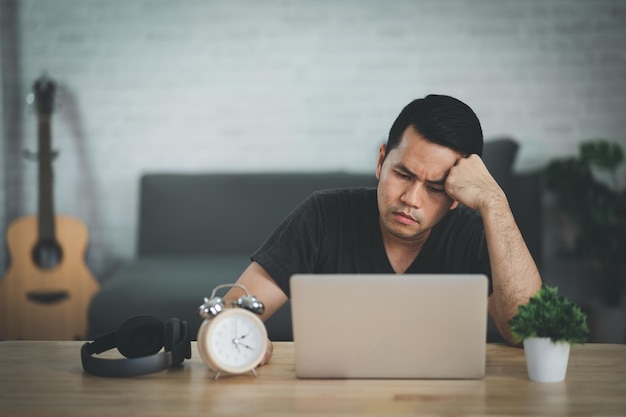 Homem freelance asiático tendo depressão estressante triste tempo trabalhando no laptop em casa Homem de depressão triste serios trabalhando em casa