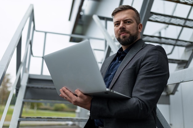 Foto homem freelancer com um laptop nas mãos em um ambiente urbano