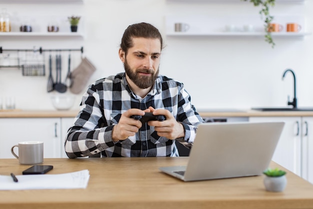 Homem freelancer fazendo uma pausa e jogando videogames depois do trabalho