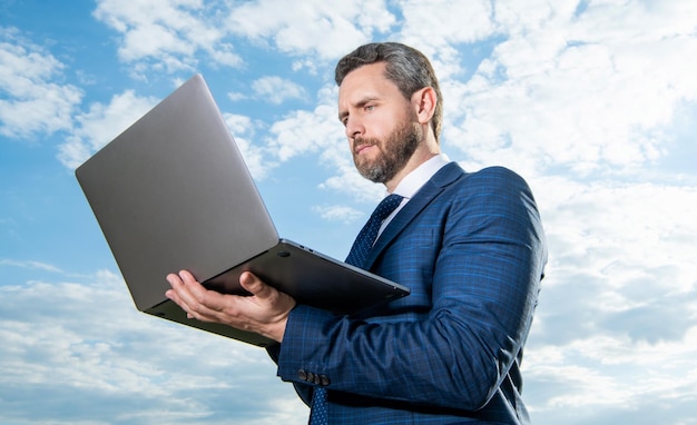 Homem freelancer trabalhando no laptop freelancer ao ar livre com laptop vestindo terno