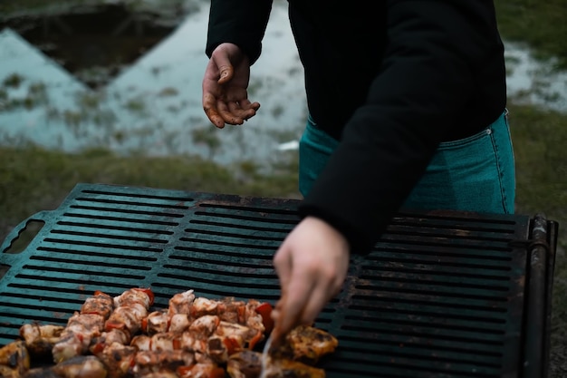 Homem fritando espetos de carne no conceito de comida caseira grelhada