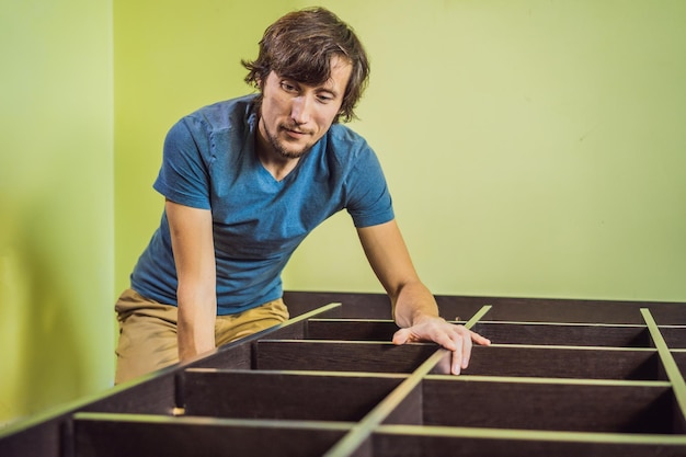 Homem frustrado montando móveis de montagem automática