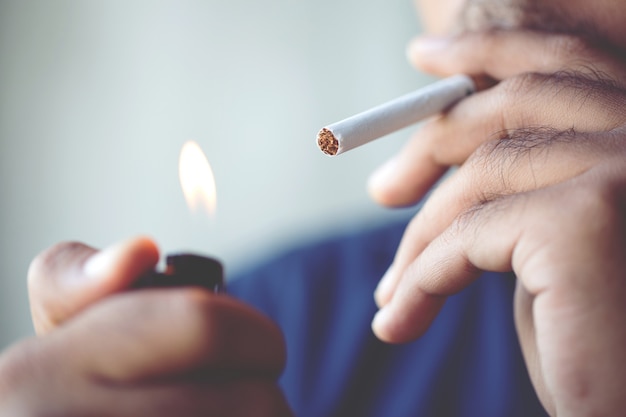 Homem fumando um cigarro. a fumaça do cigarro se espalhou.