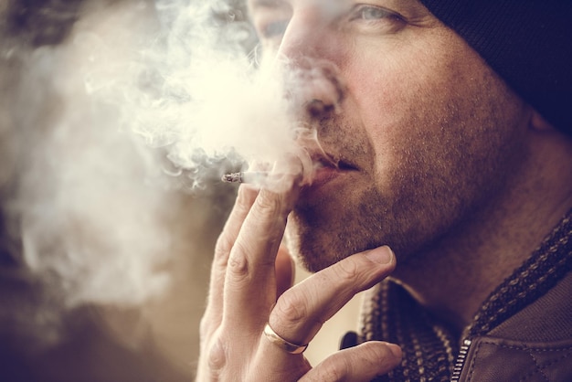Homem fumando um cigarro propagação de fumaça de cigarro