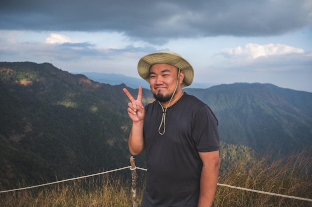 Homem gordo asiático com bela vista da montanha khao San nok wua kanchanaburiKhao San Nok Wua é a montanha mais alta do Parque Nacional Khao Laem É 1767 metros acima do nível do mar