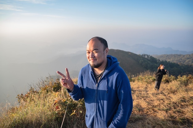 Homem gordo asiático com belo nascer do sol da montanha khao san nok wua kanchanaburikhao san nok wua é a montanha mais alta do parque nacional khao laem é 1767 metros acima do nível do mar