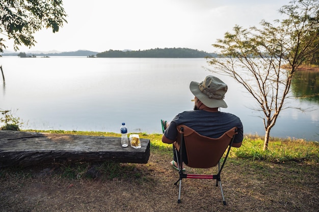 Homem gordo asiático sentado na cadeira de acampamento com bela paisagem do ponto de vista pompeePom Pee viewpoint está localizado no Parque Nacional Khao Laem Thong Pha Phum distrito província de Kanchanaburi