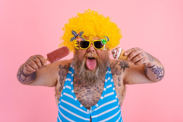 Homem gordo com barba e peruca comendo um picolé e um sorvete